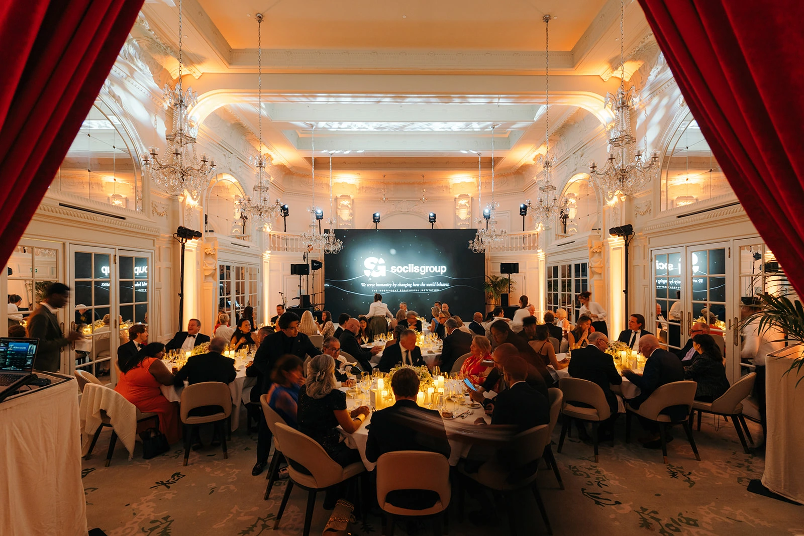 People sharing hospitality and conversation at The 64, with sociisgroup’s purpose on stage